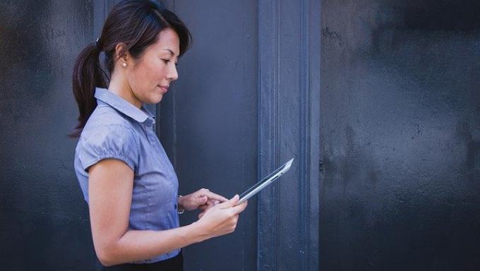 femme de profil qui regarde sa tablette